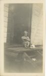 1910 ca. CAT Young seated boy with bowl next to cat eating from plate RPPC front